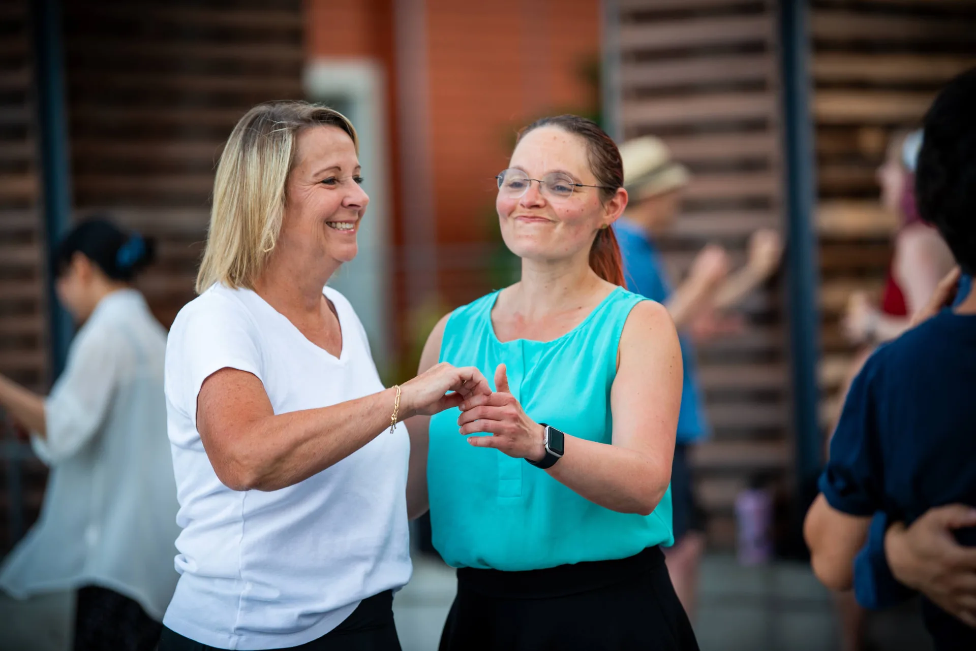 Two women dancing together and smiling at the free Bellevue City Hall event.