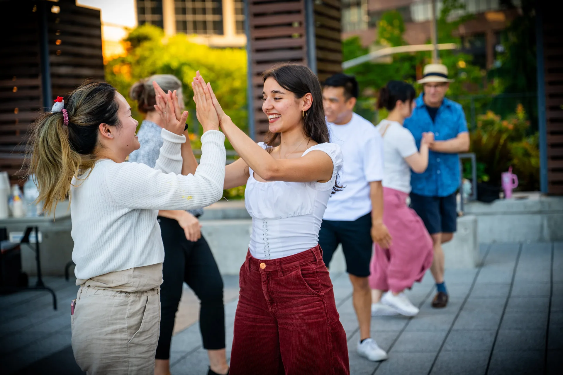 Two dancers smiling and touching hands during the free Bellevue City Hall event, with other dancers behind them.